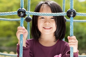 Smiling asian girl on a playground, horizontal