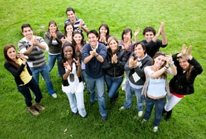 casual friends smiling and clapping upwards in the park