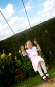 happy girl on a swing in a children playground