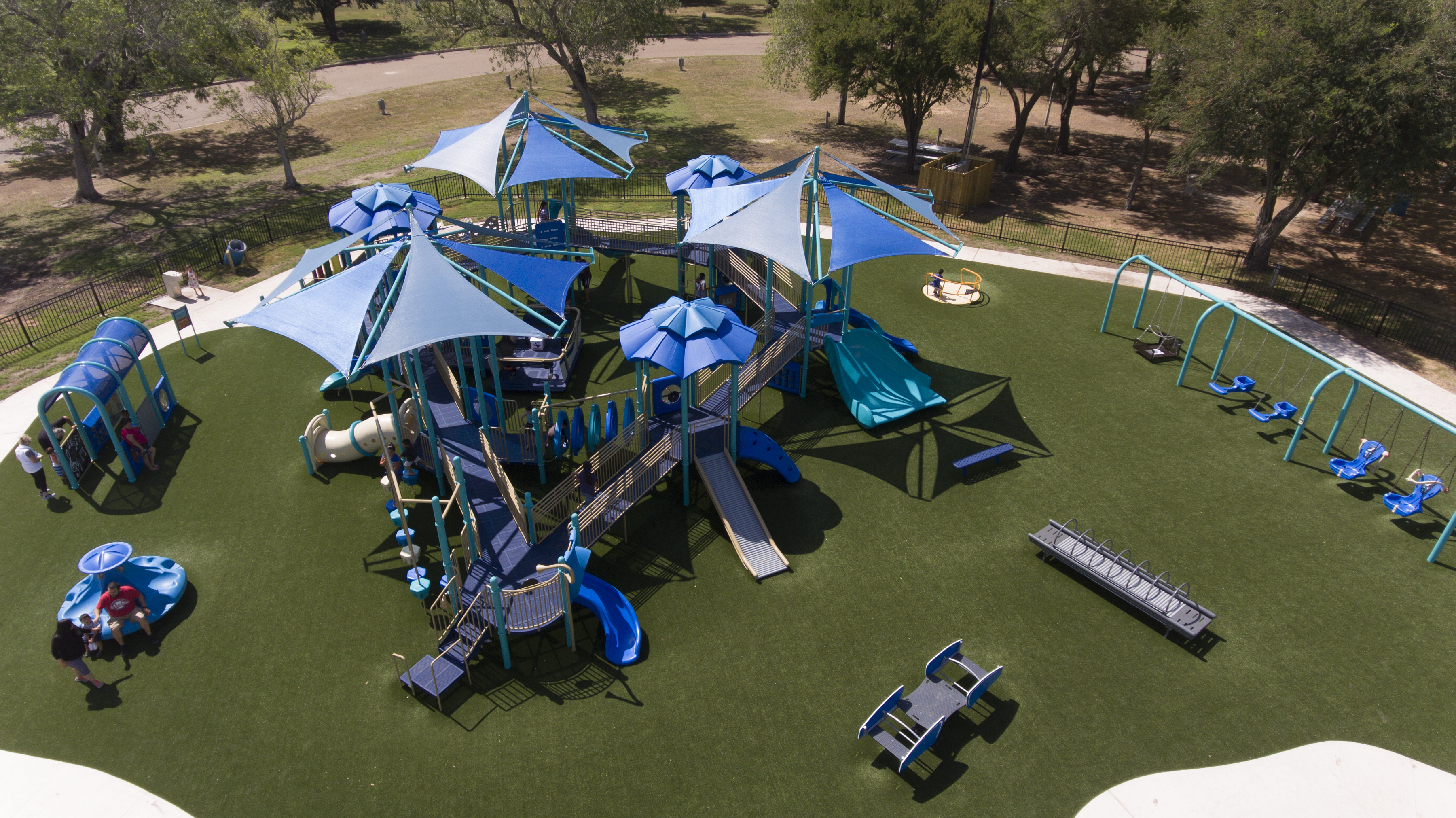 Families playing on an inclusive playground. 