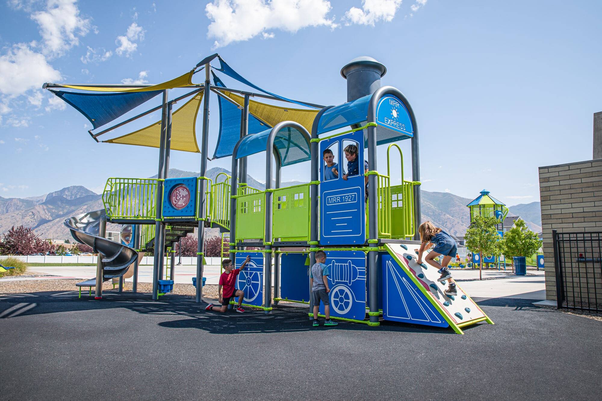 Children playing on a playground that looks like a train