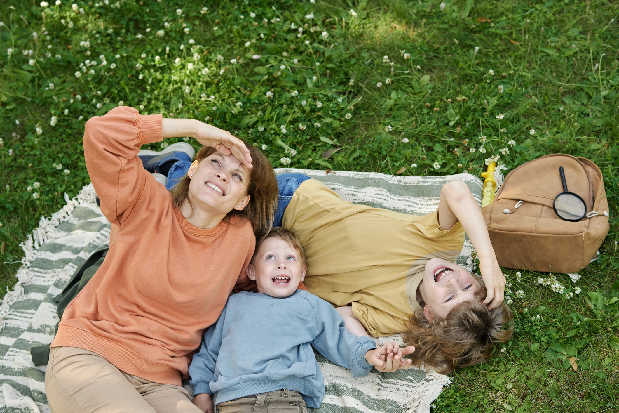 Mother and sons playing in a park. 