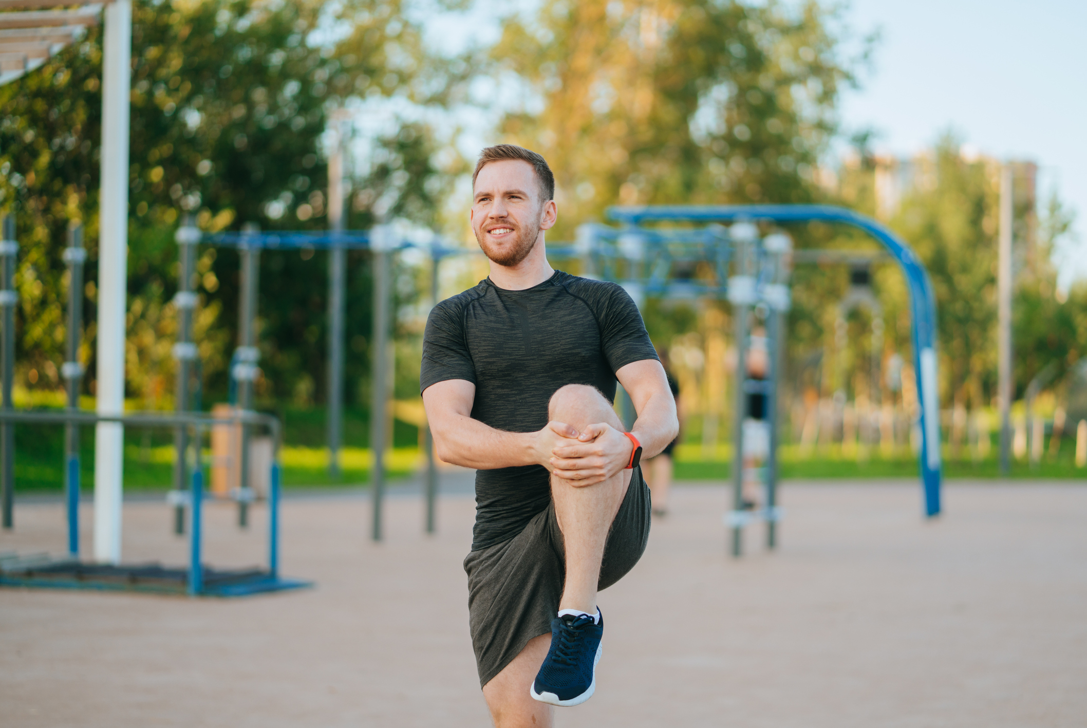 Man in athletic clothing stretching his legs at an outdoor recreation space